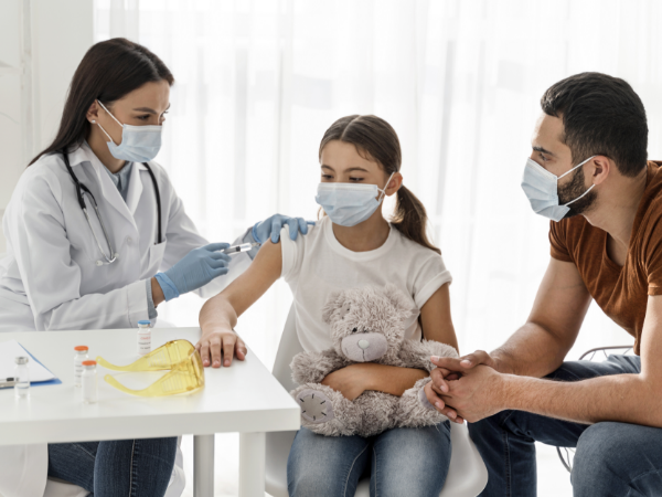 Doctor examining the girl using stethoscope