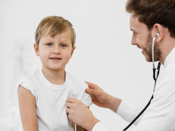 Doctor examining the kid using stethoscope